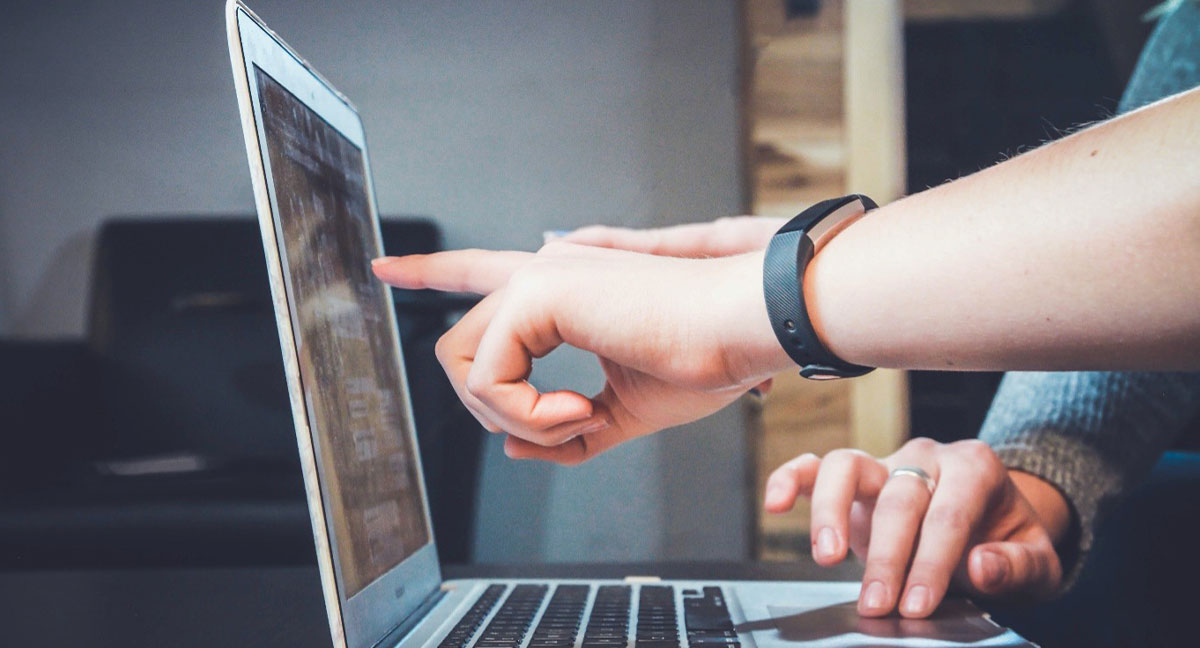 person pointing at computer