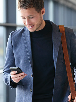 Man in airport using mobile phone