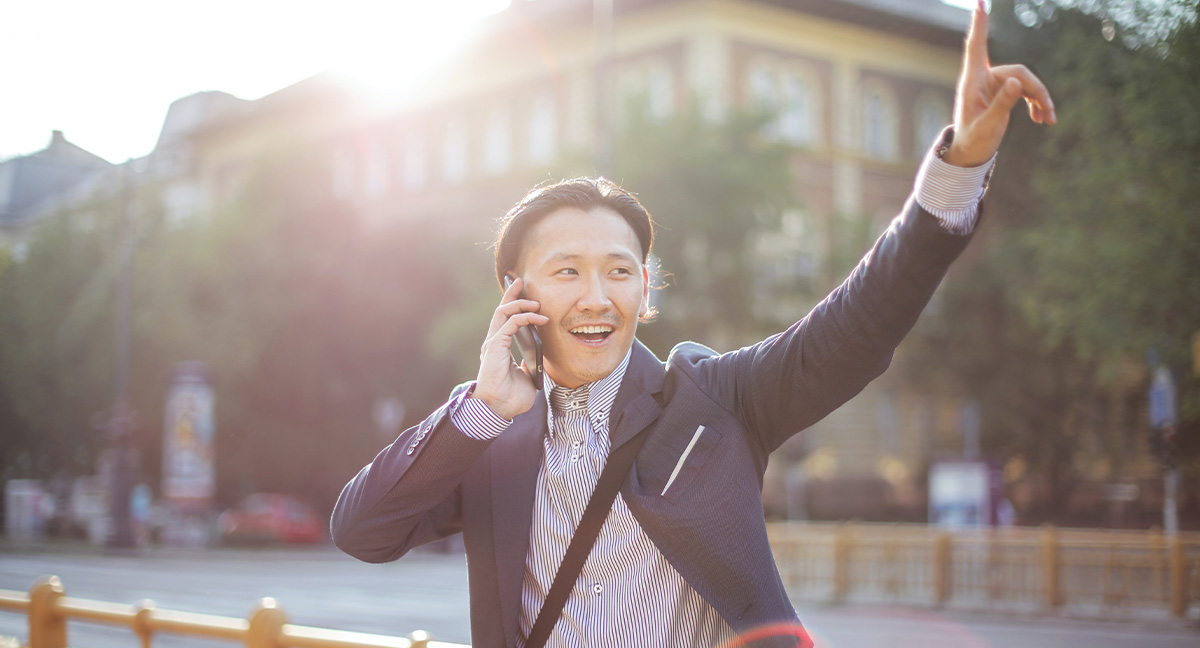 man on phone pointing finger into sky